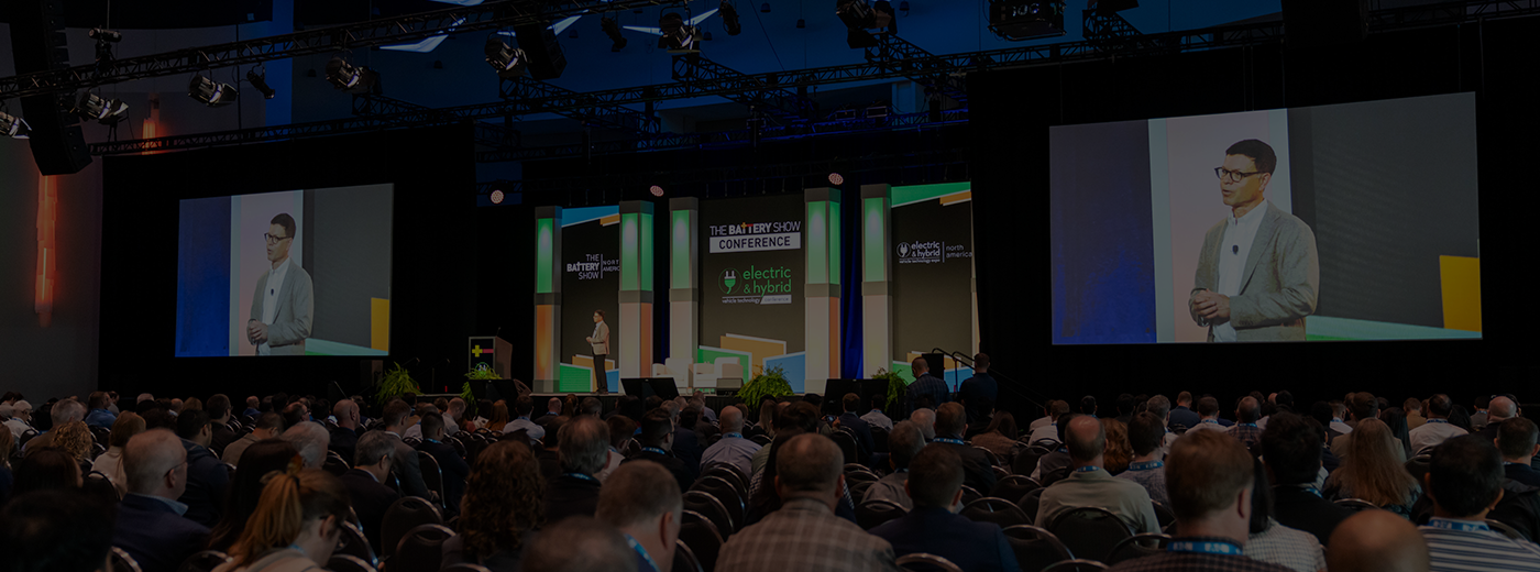 A bustling conference room filled with a diverse crowd of attendees participating in an event.