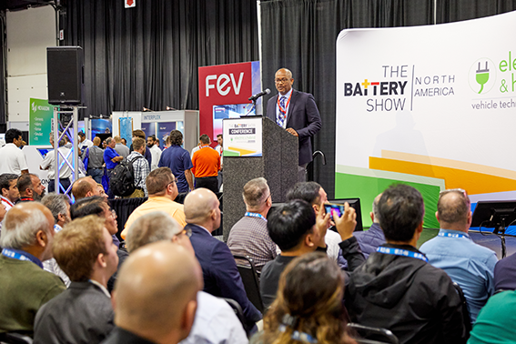 A speaker stands at a podium, presenting to an attentive audience in The Battery Show