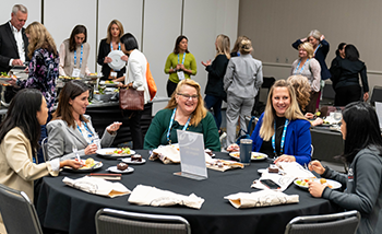 A table filled with food as a group of friends or family members enjoy a meal together, smiling and engaging.