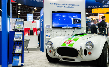 A sleek white and green sports car showcased prominently at an exhibition, highlighting its modern design and features.